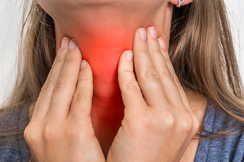 Woman experiencing a sore throat