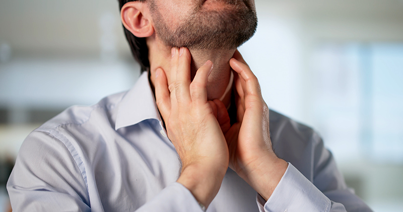 Close-up of a man experiencing throat pain